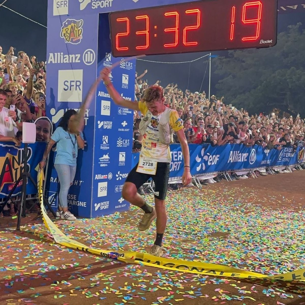 Baptiste Chassagne franchit la ligne d'arrivée sous le chrono de l'arche, devant une foule dense et des confettis