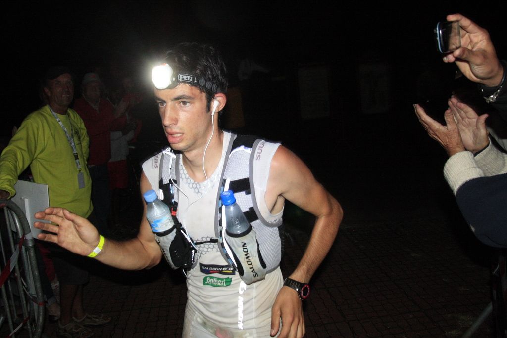 Kilian Jornet, frontale allumée, arrive de nuit à un point de passage sous les applaudissements